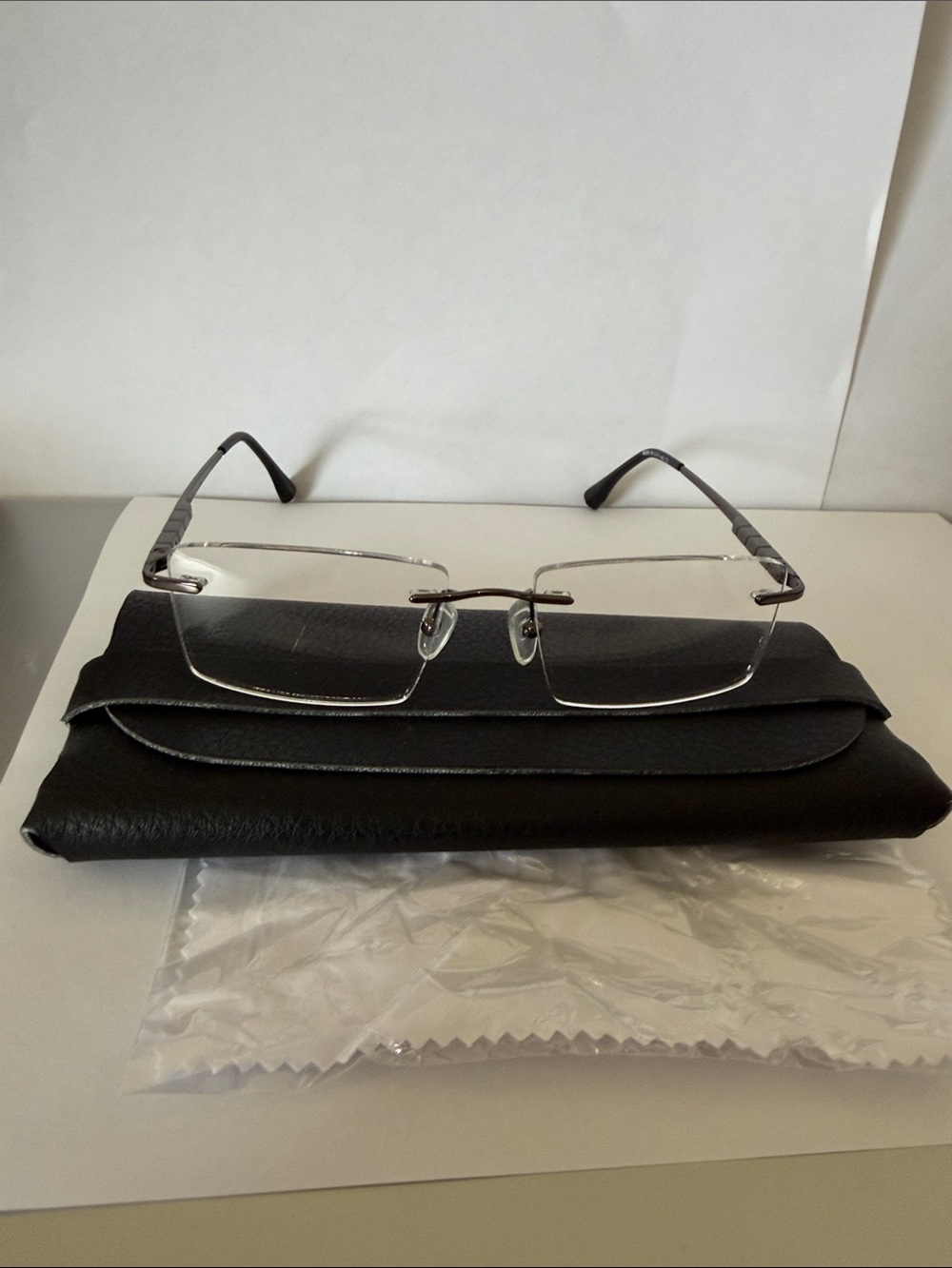 Black Men's Eyeglass Case with Gunmetal Rimless Glasses Frame.